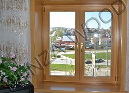 Двустворчатое окно из евробруса с деревянными откосами и деревянным подоконником.